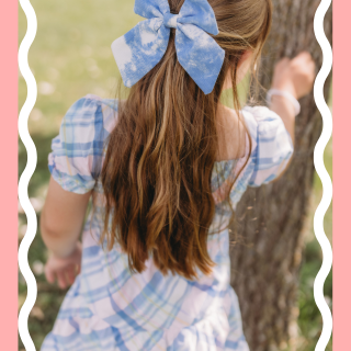 Girl facing away wearing plaid dress and bow in hair